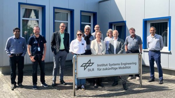 Group of scientists standing in front of a building with windows
